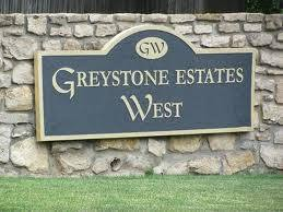 The Greystone Estates West entrance sign on a stone wall